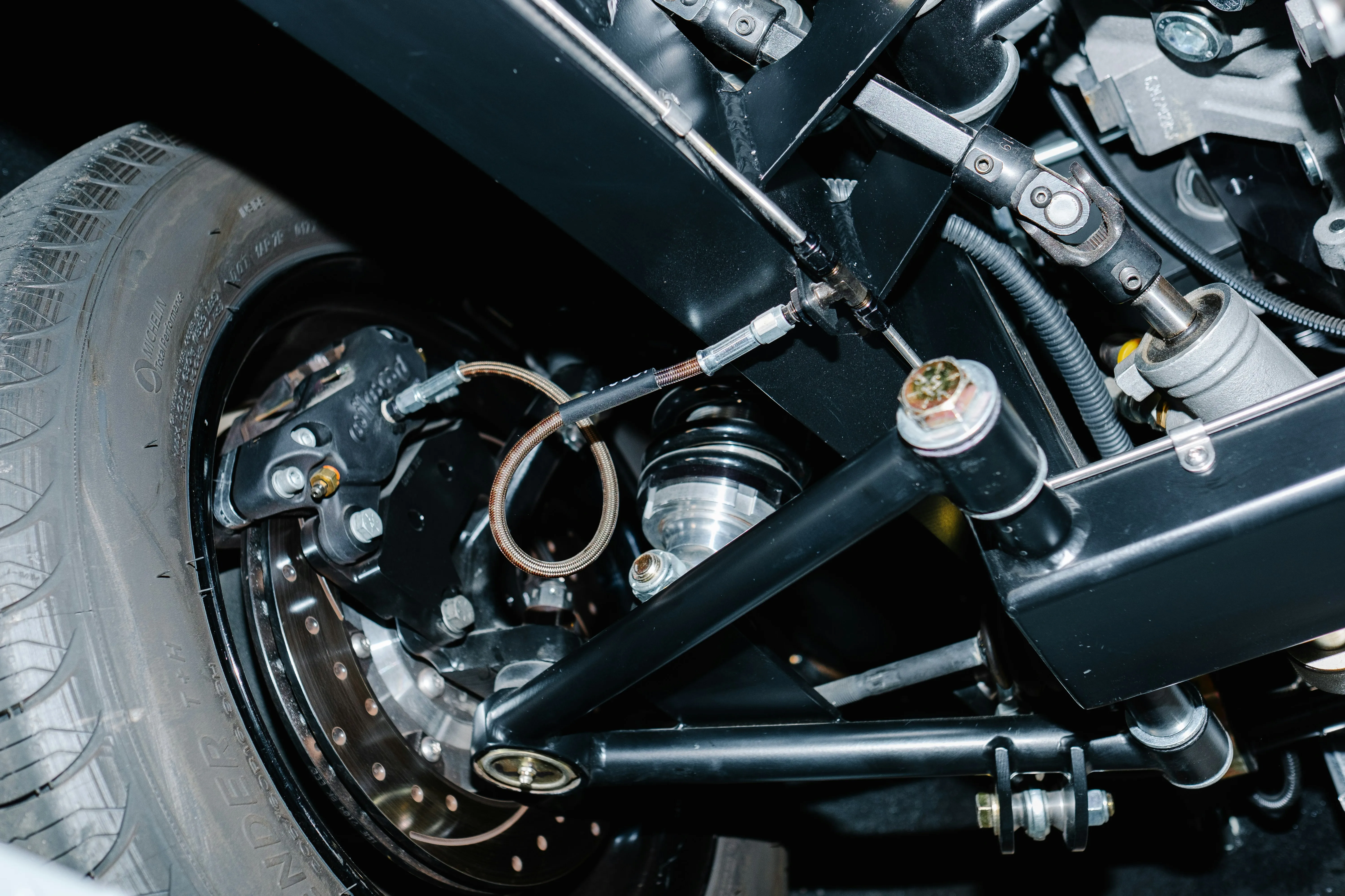Mechanic working on a car, surrounded by tools and automotive parts.